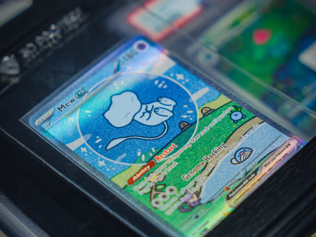 A single holographic card catching the light in its sleeve.