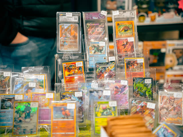 Graded and top-loaded Pokemon cards stood up on display risers.