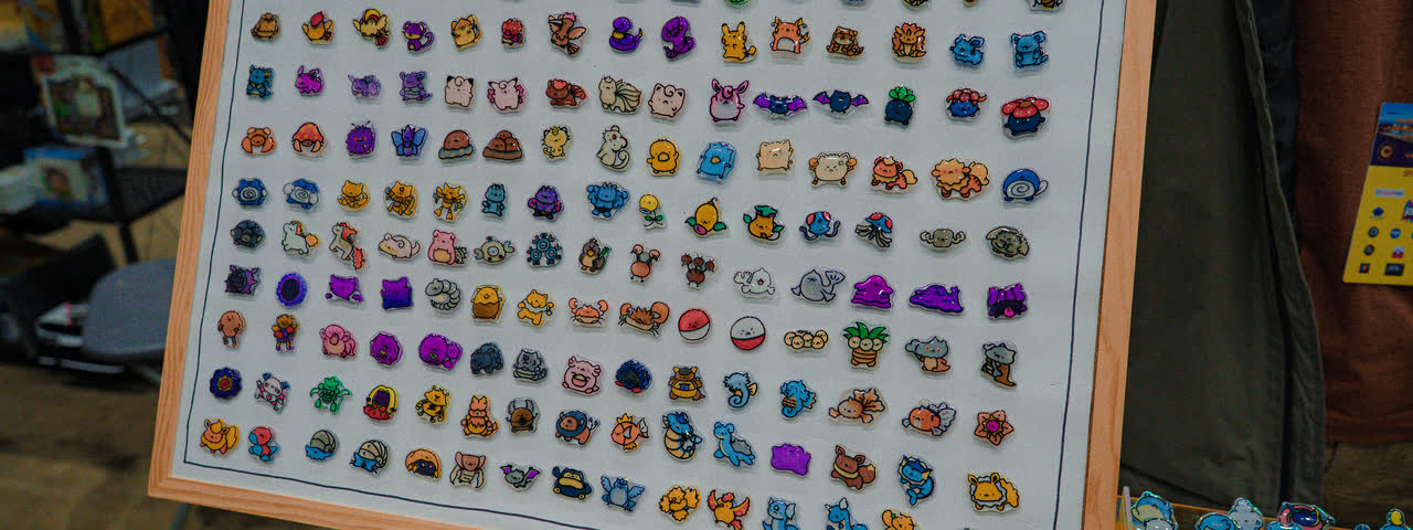 A board of tiny handmade Pokemon pins on an easel.