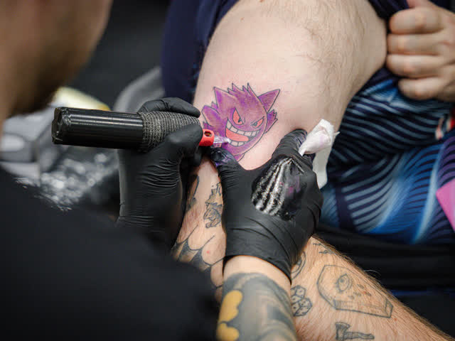 A Gengar tattoo being inked onto a customer arm.