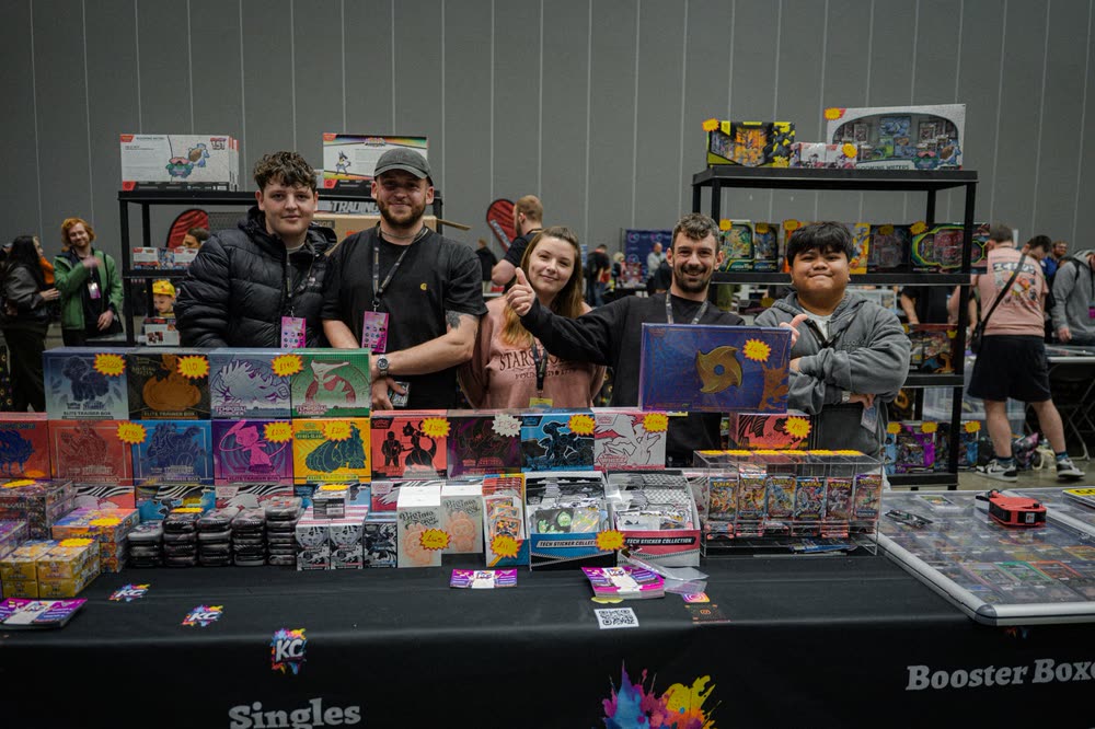 The KC Collectables team behind a table stacked with sealed Pok&eacute;mon boxes
